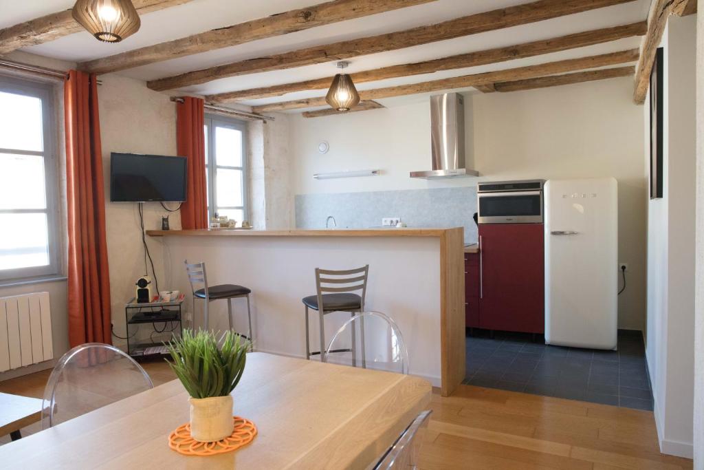 图尔尼Appartement A-Mi-Chemin - Centre-ville de Tournus的一间厨房,里面配有桌椅