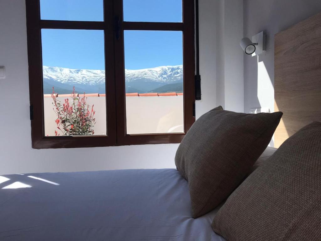 Jerez del MarquesadoHotel El Picón de Sierra Nevada的一张带窗户的床铺,享有雪覆盖的山脉美景
