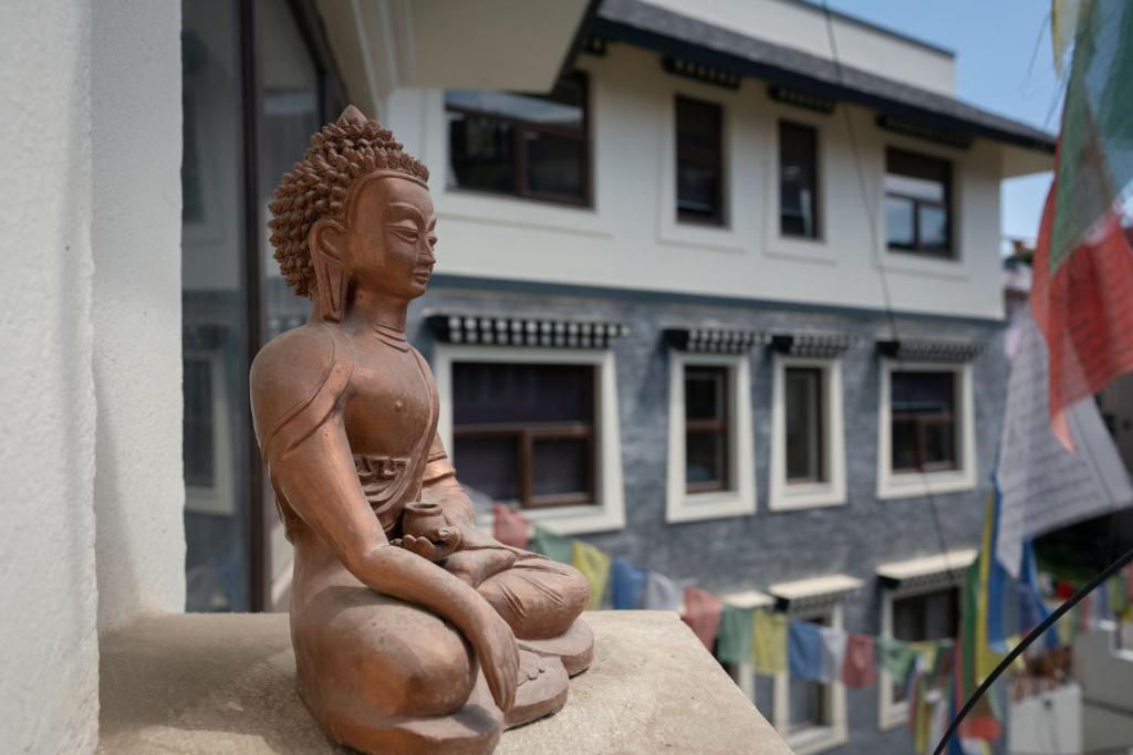 加德满都ViaVia Boutique Hotel - Kathmandu的坐在建筑物顶端的女人的雕像
