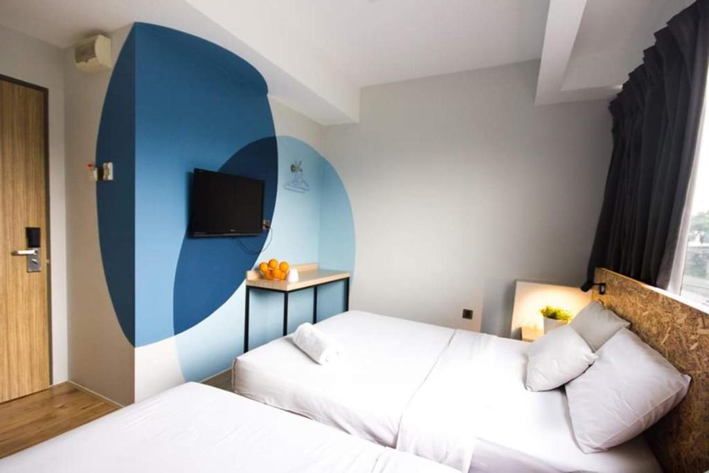 吉隆坡i-Hotel Kuala Lumpur的一间酒店客房,设有两张床和电视