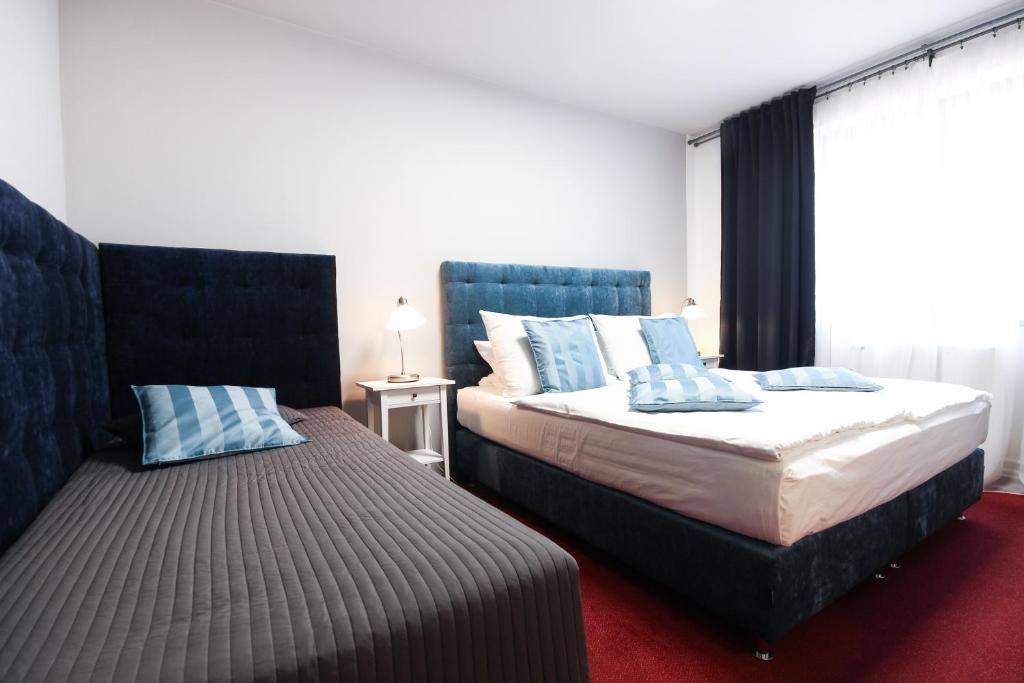 米库洛夫米库洛夫莫洛里酒店的一间卧室配有两张带蓝色枕头的床