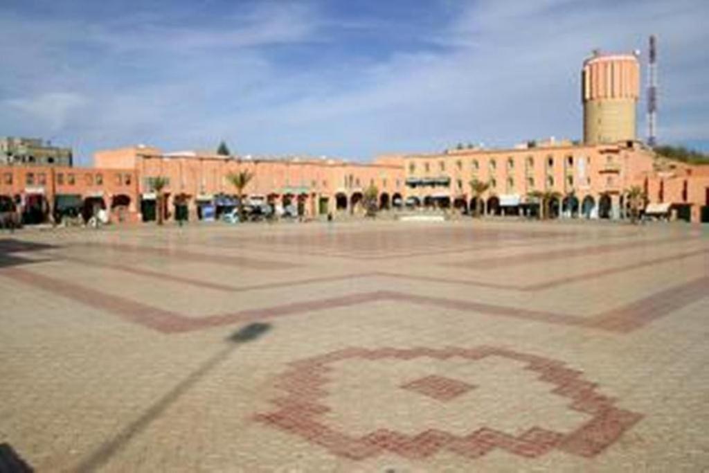 瓦尔扎扎特巴布撒哈拉酒店的地面上带有红色标志的大型砖砌建筑