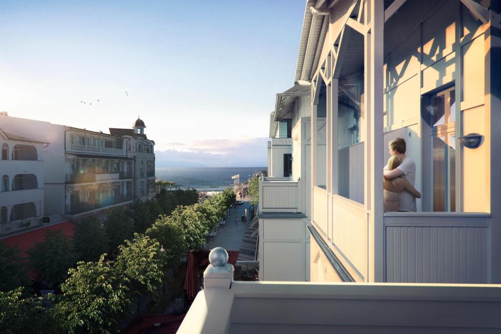宾茨LOEV - VELA Hotels的站在建筑物阳台上的妇女
