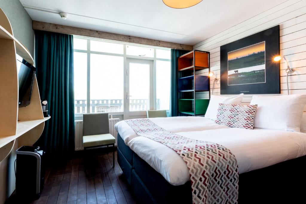 柯德科克Strandhotel Westduin的酒店客房设有一张床和一个大窗户