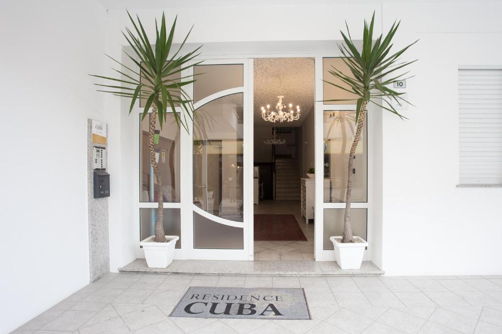 里乔内Residence Cuba的门前有两棵棕榈树的商店