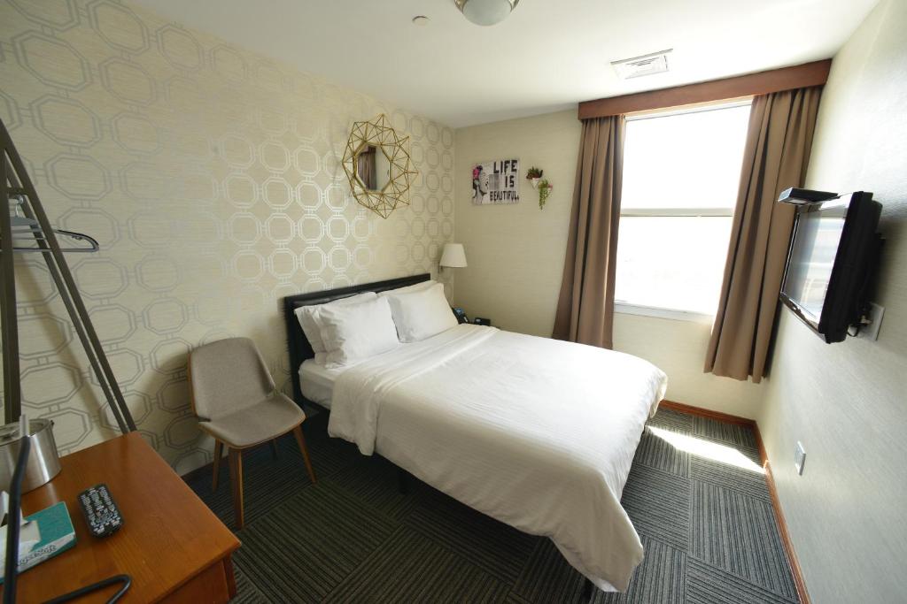 纽约蔤蒙莎酒店的酒店客房设有白色的床和窗户。