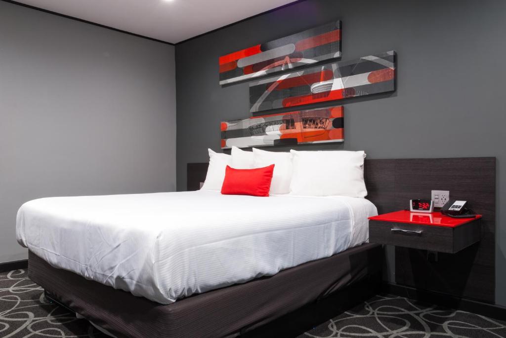 帕萨迪纳帕萨迪纳阿斯特罗酒店的一间卧室配有一张带红色枕头的大床