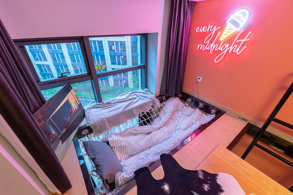 杭州loft Apartment with slide hammock with movie viewing的小房间设有床和窗户