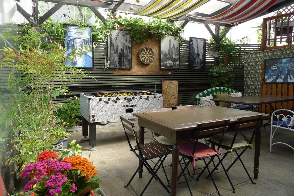 束草市豪斯旅舍的庭院配有桌椅和鲜花