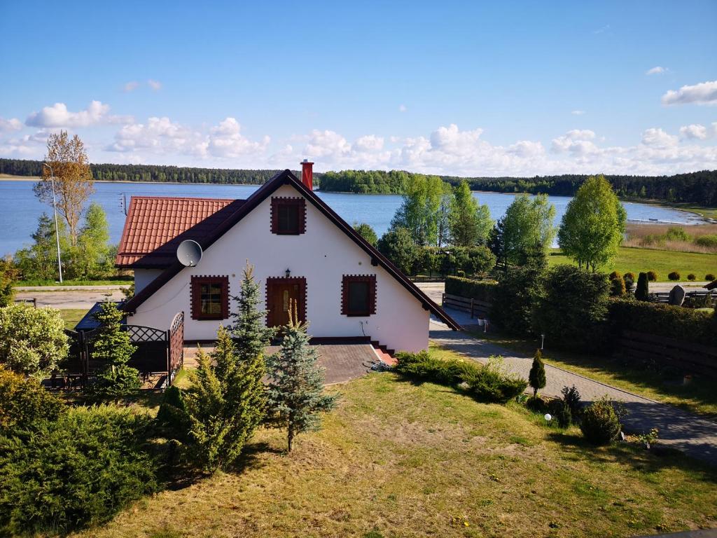 KiedrowiceAgroturystyka Dobri mól的一座白色的小房子,后面有湖泊