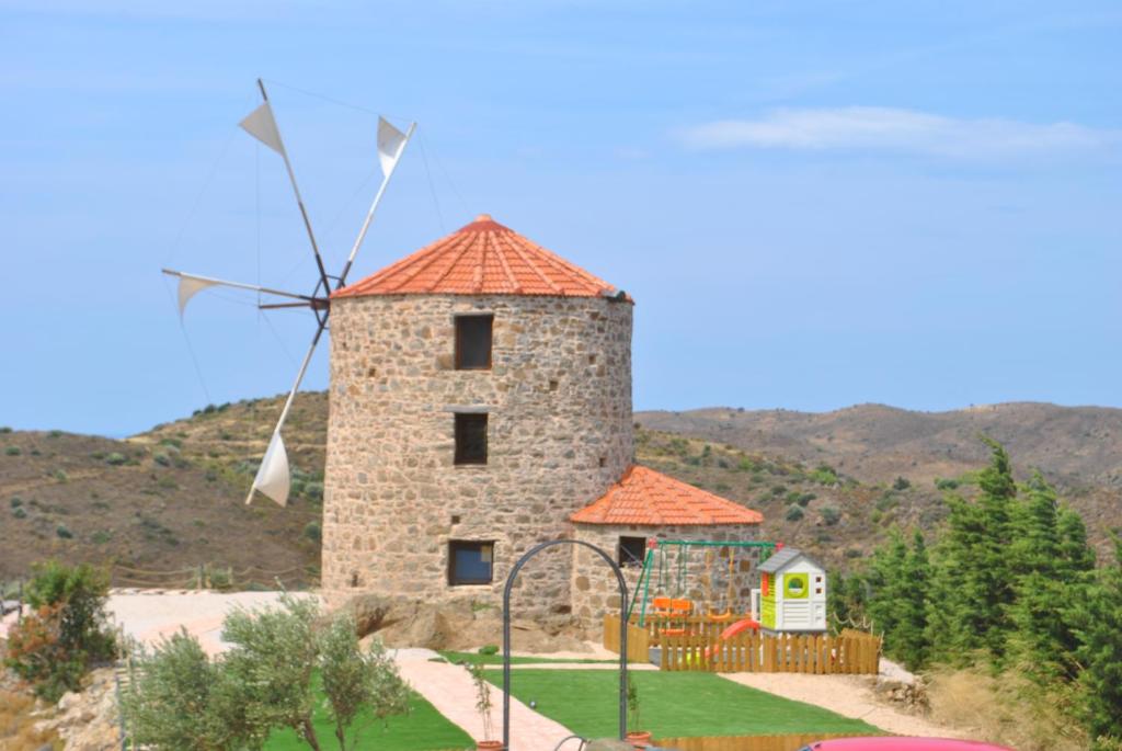 VolissosΑνεμόμυλος του Οδυσσέα的一座在院子里有风车的建筑