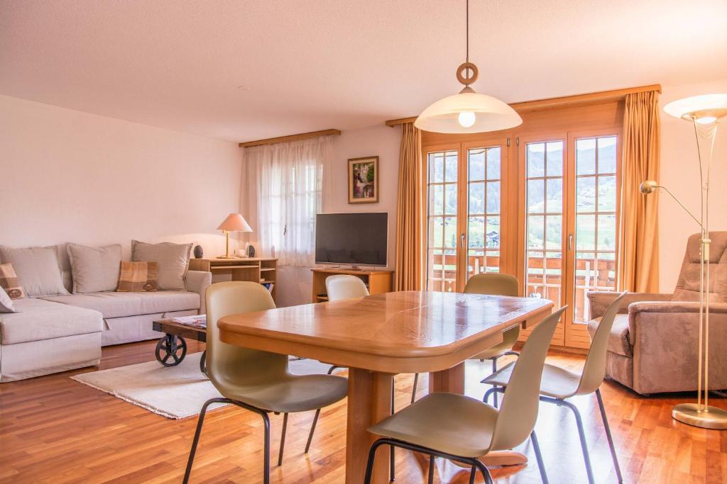 格林德尔瓦尔德圣路易斯2.5公寓 - 格林瓦租赁股份有限公司的客厅配有木桌和椅子