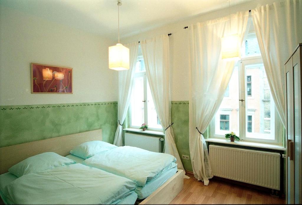 德累斯顿路易斯20号酒店的一间卧室设有一张床和两个窗户。