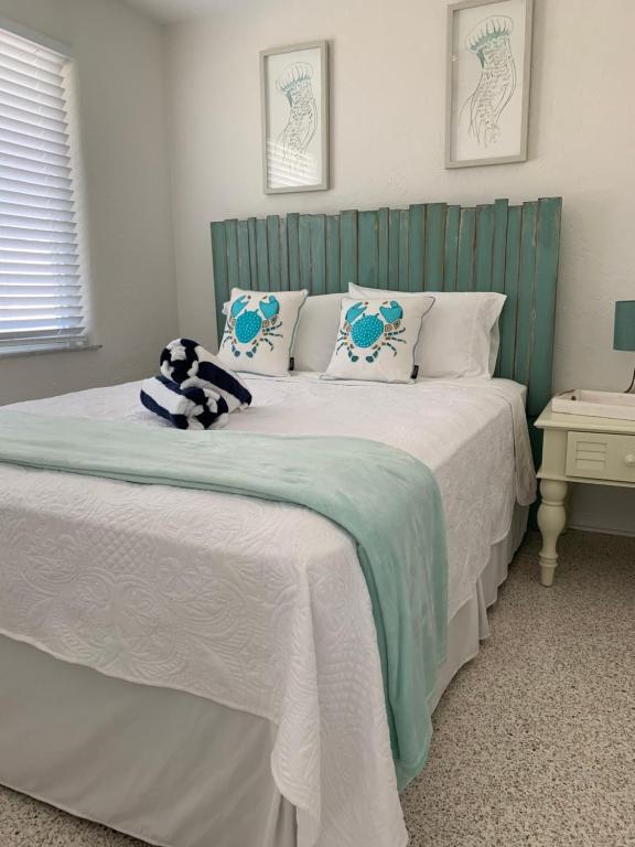 新士麦那海滩Ocean Eleven Suites的一间卧室配有一张带绿色床头板的床