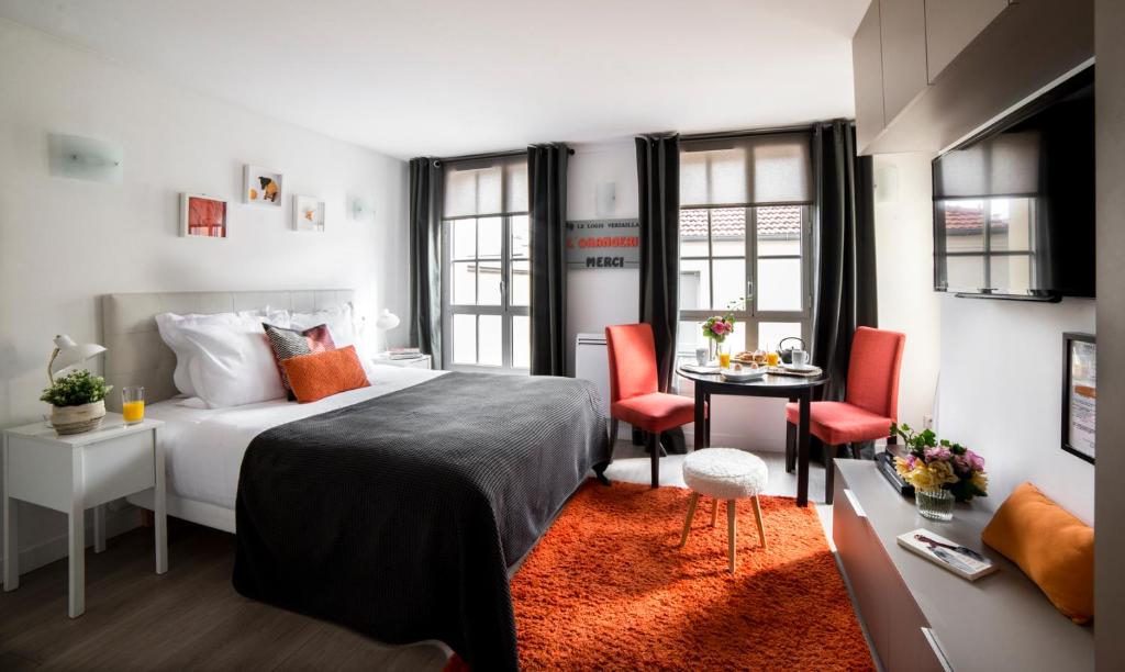 凡尔赛凡尔赛罗杰斯公寓的卧室配有一张床和一张桌子及椅子