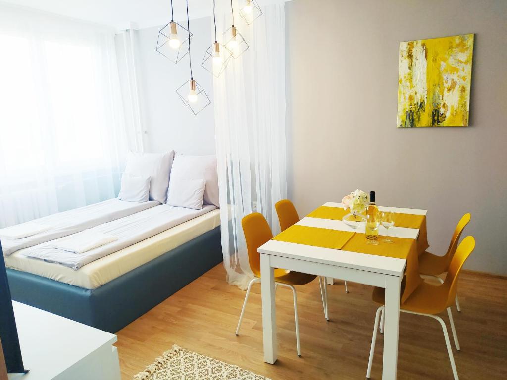 尼赖吉哈佐Lora Apartman的配有一张床和一张桌子及椅子的房间