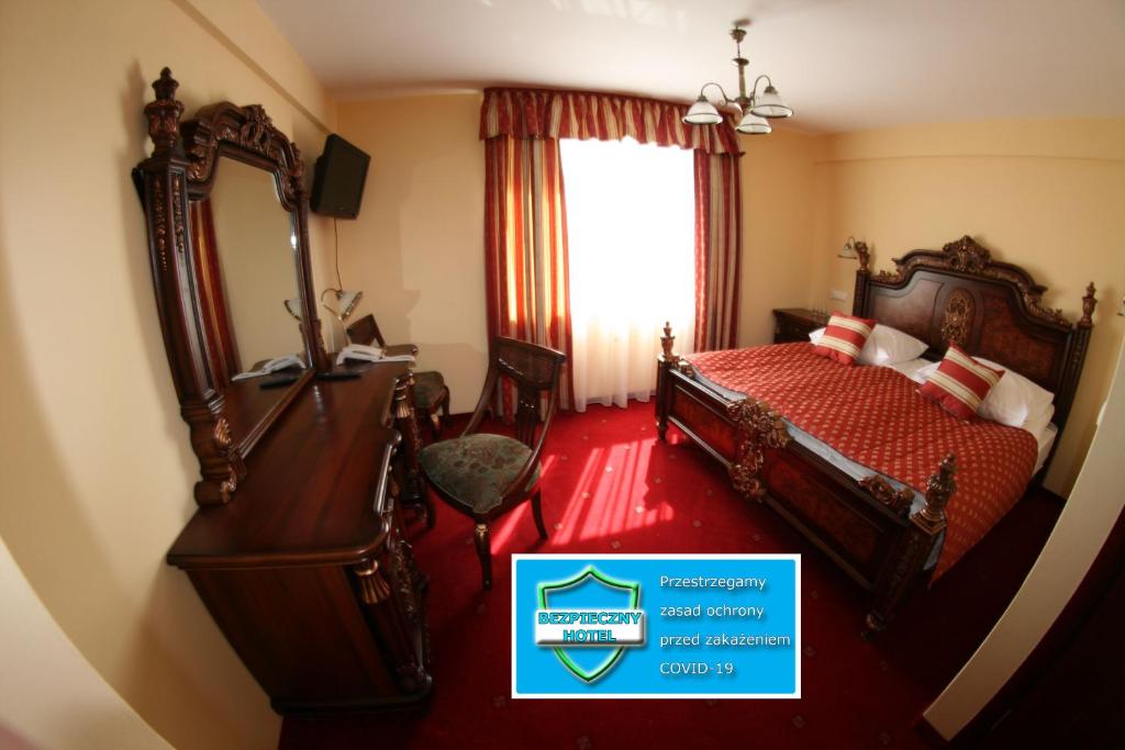 克拉科夫黛西高级酒店的酒店客房,配有床和镜子