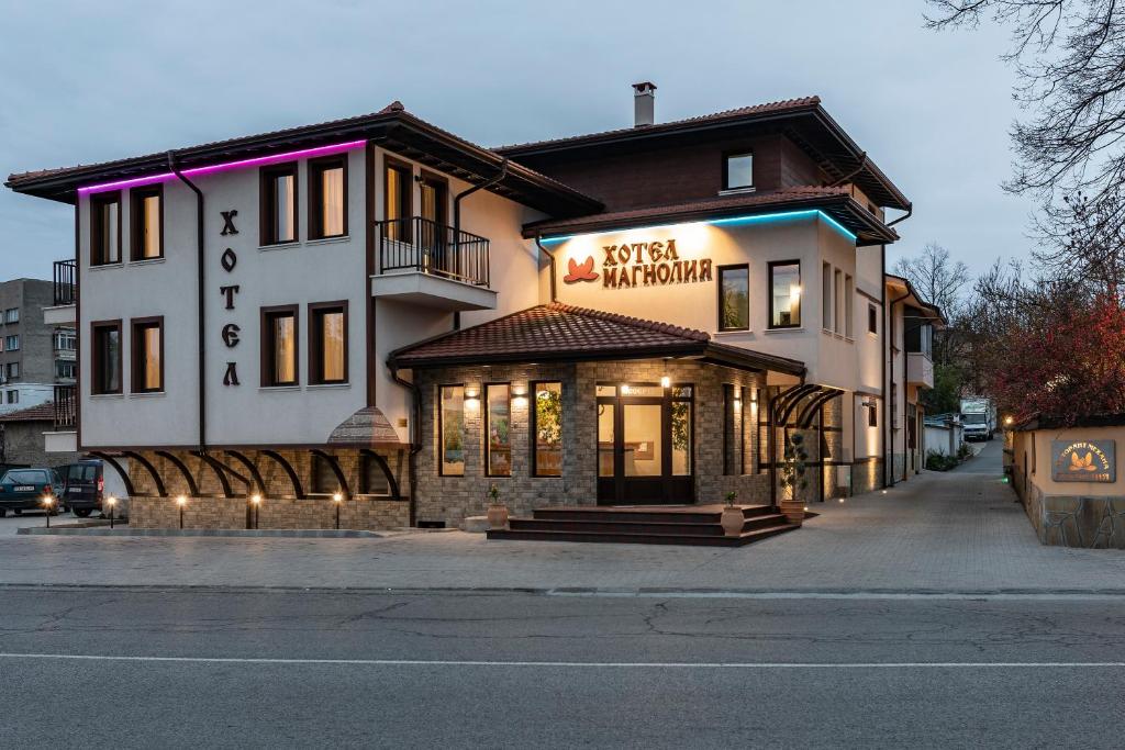 卡赞勒克Семеен хотел Магнолия的带有餐厅标志的建筑