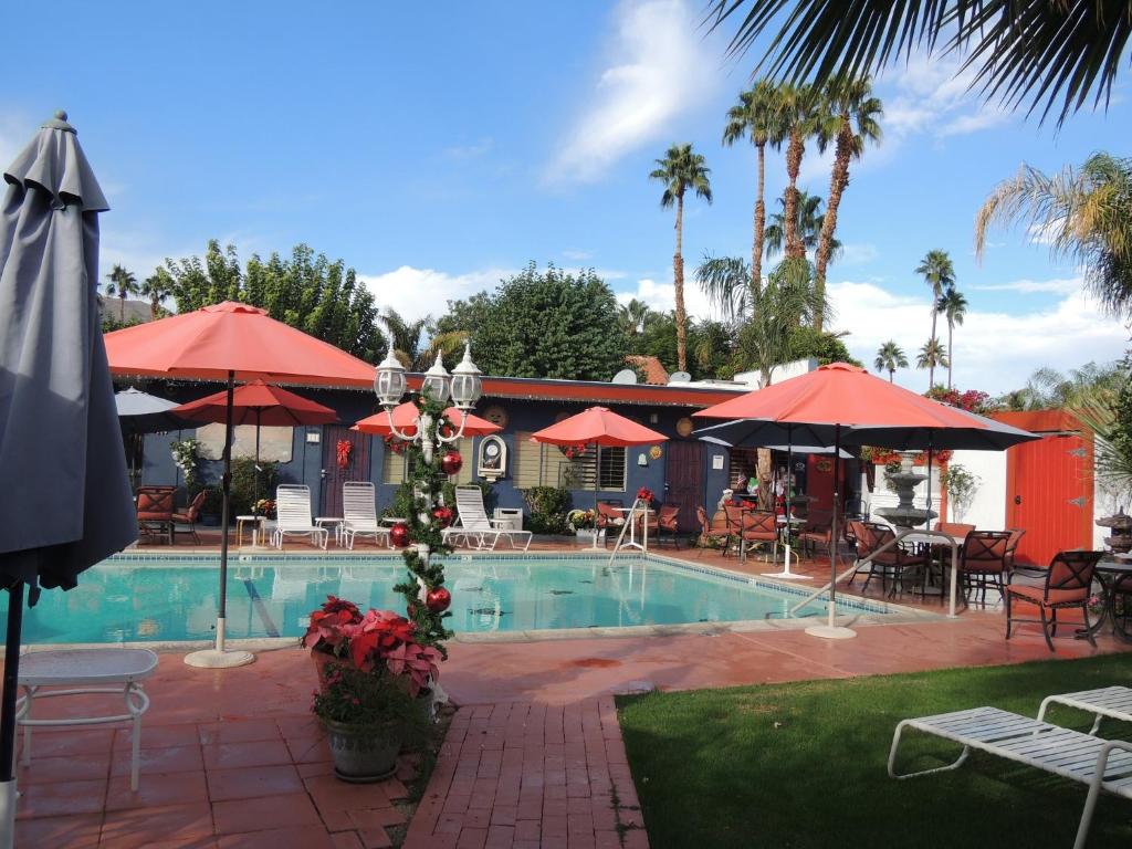 棕榈荒漠卡萨德拉雷亚酒店的一个带桌子和遮阳伞的游泳池和一间餐厅