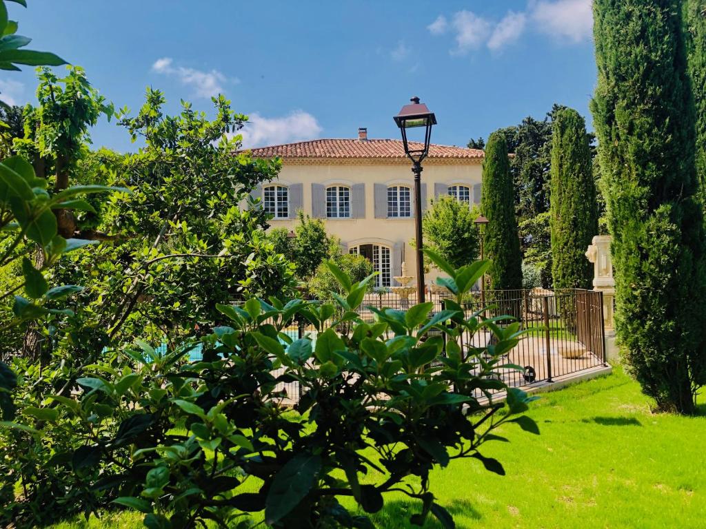 奥朗日Villa Agrippa的一座带大门和树木的大房子