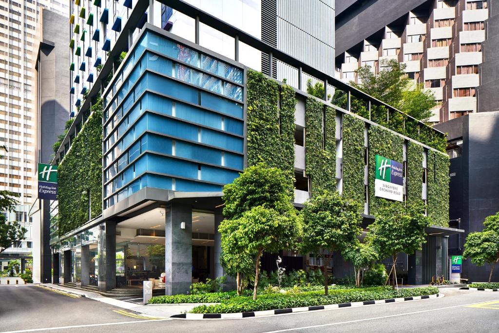 新加坡Holiday Inn Express Singapore Orchard Road, an IHG Hotel的蓝色的建筑,在它的侧面有植物