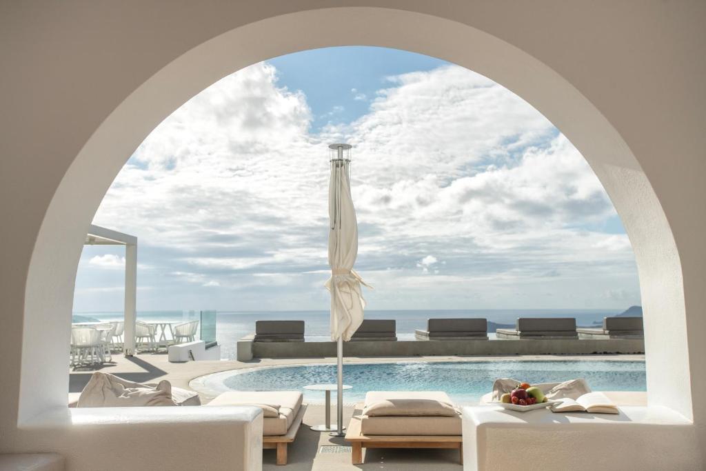 费拉Lilium Hotel Santorini的俯瞰游泳池的拱门,享有海景