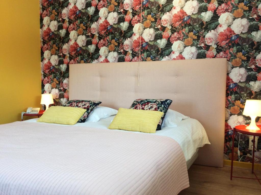 泽伊恩克尔克Boutique Hotel Butler的一间卧室配有两张带花卉壁纸的床