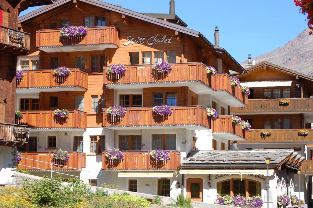 萨斯费Apartment Swiss Chalet的一座大建筑,阳台上放着花盒