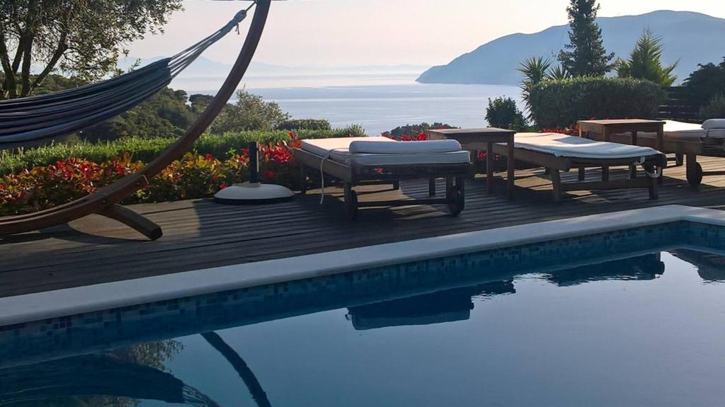 阿洛尼索斯古镇Villa Mirothea Alonissos的游泳池旁设有椅子和吊床