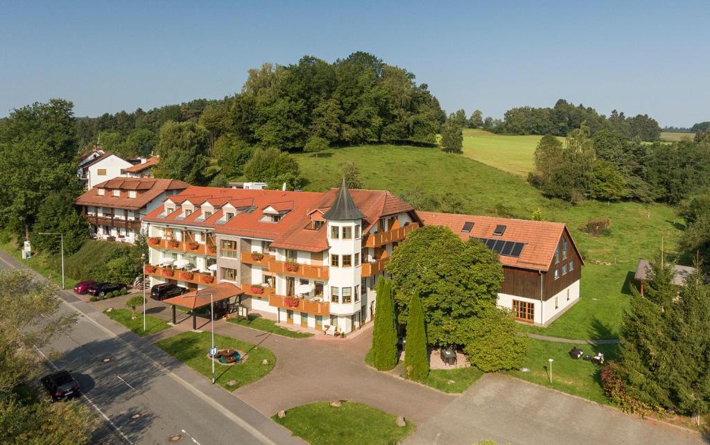 Grasellenbach库勒尔格朗德酒店的山丘上一座大建筑的空中景观