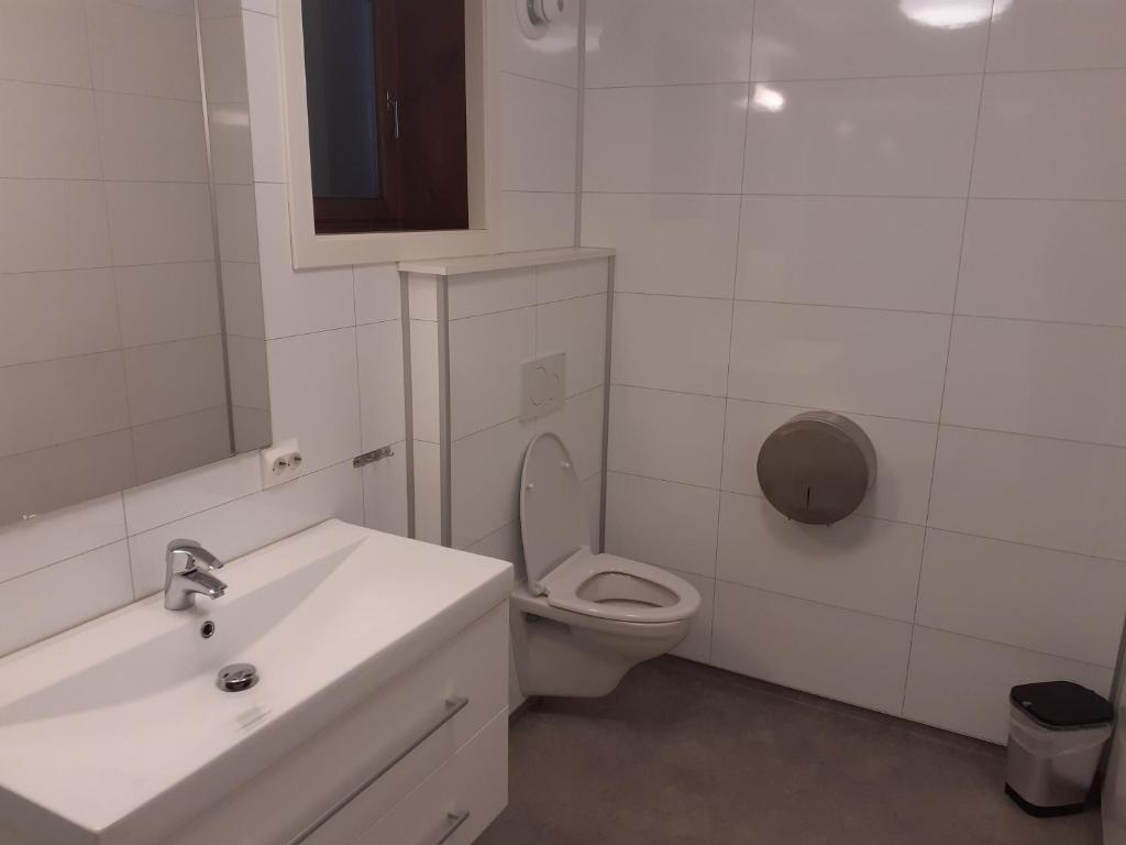 Skudeneshavn尚酷德尼森露营酒店的白色的浴室设有卫生间和水槽。