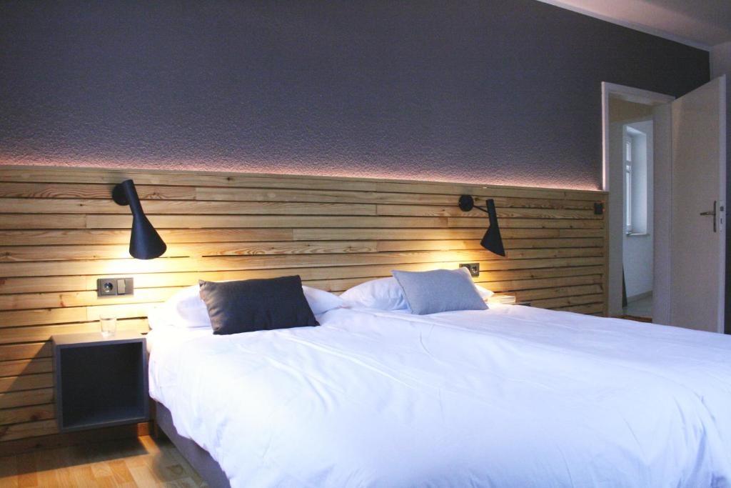 萨克森自由州诺伊斯塔滕FEWO am Markt的卧室配有一张白色大床和木制床头板