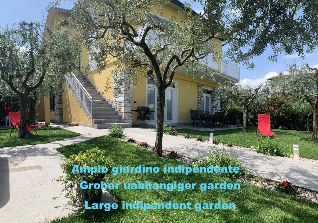 佩斯基耶拉德加达Villa Lori Apartments Garden and Beach的院子里有树的黄色房子