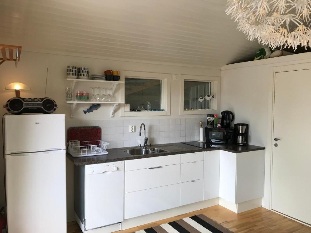 卢恩斯基尔Lyckhus的厨房配有白色橱柜、水槽和冰箱。
