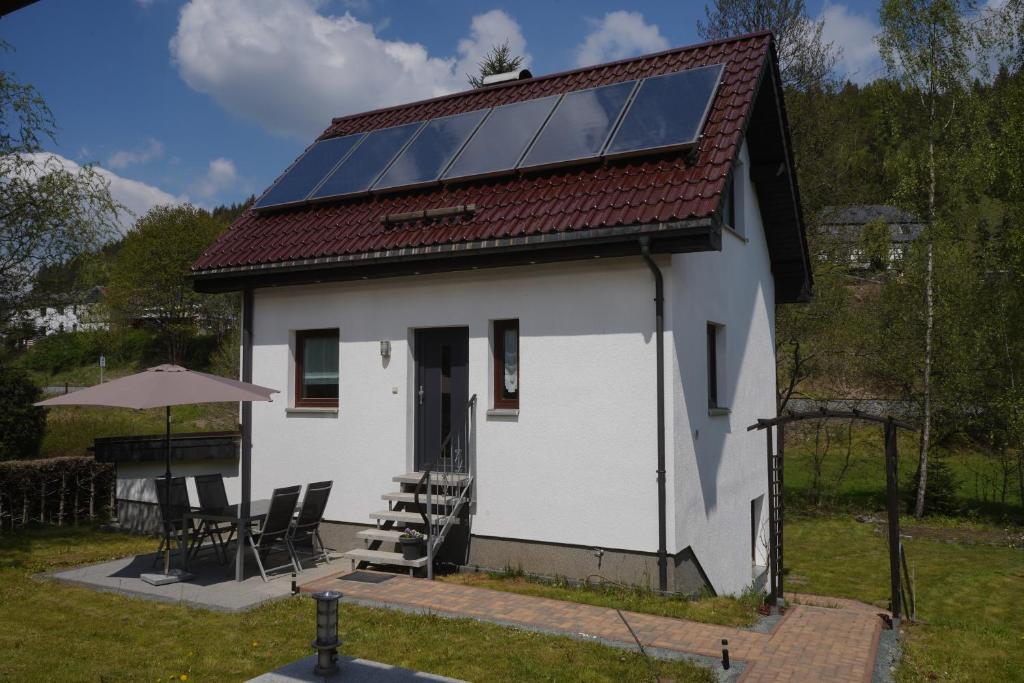 ZwotaFerienhaus Familie Lorenz的一座白色的房子,屋顶上设有太阳能电池板