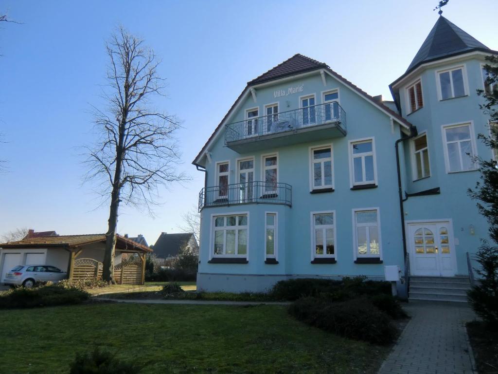 奥斯赛拜-屈隆斯博恩Ferienwohnung Ostseeglück in der Villa Marie的院子中一棵树的白色大房子