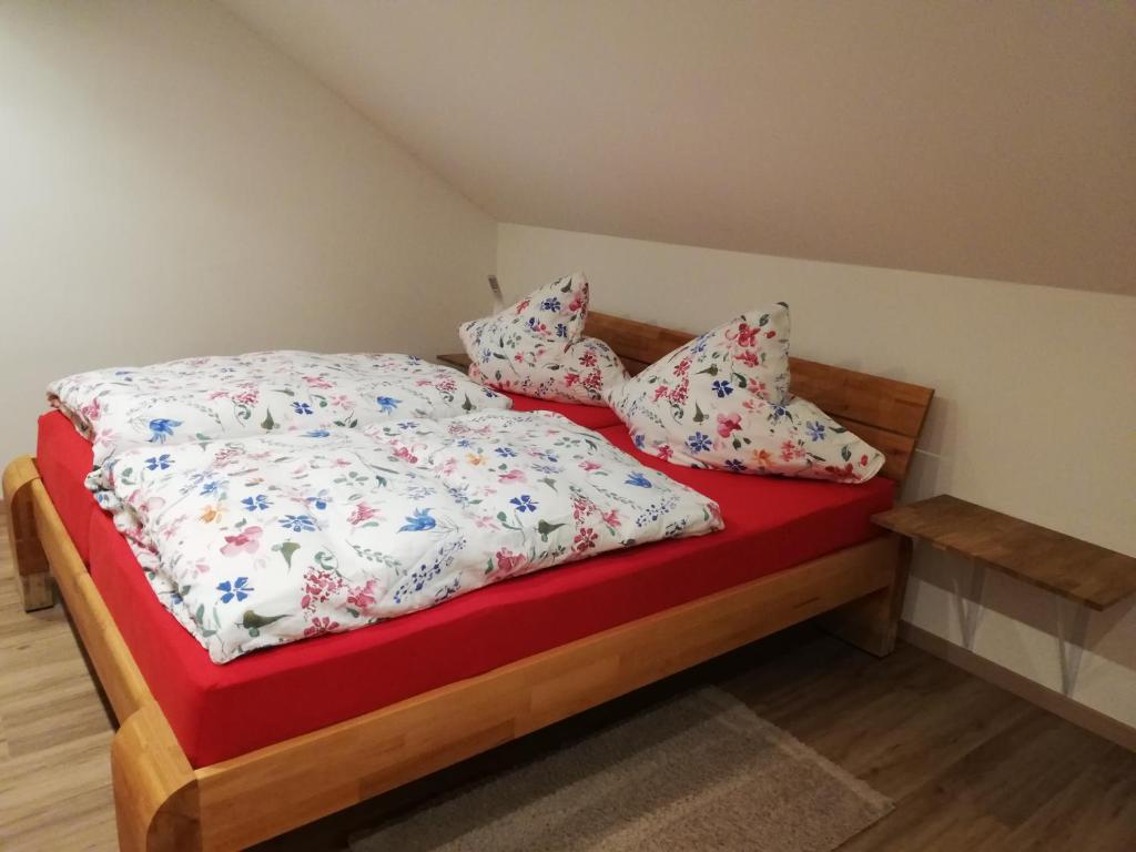 巴特维尔东根Emmerich s neu errichtete DG-Wohnung的一间卧室配有一张带红色毯子和枕头的床。