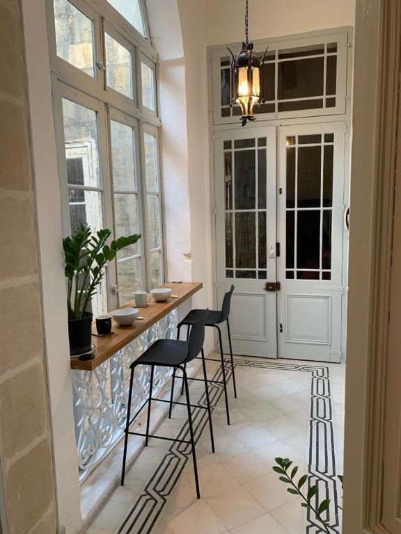 瓦莱塔Luxury Valletta Apartment的厨房设有酒吧、椅子和窗户
