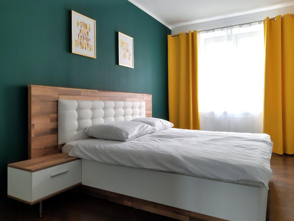 比亚韦斯托克Emerald Apartament的卧室配有白色的床和窗户。