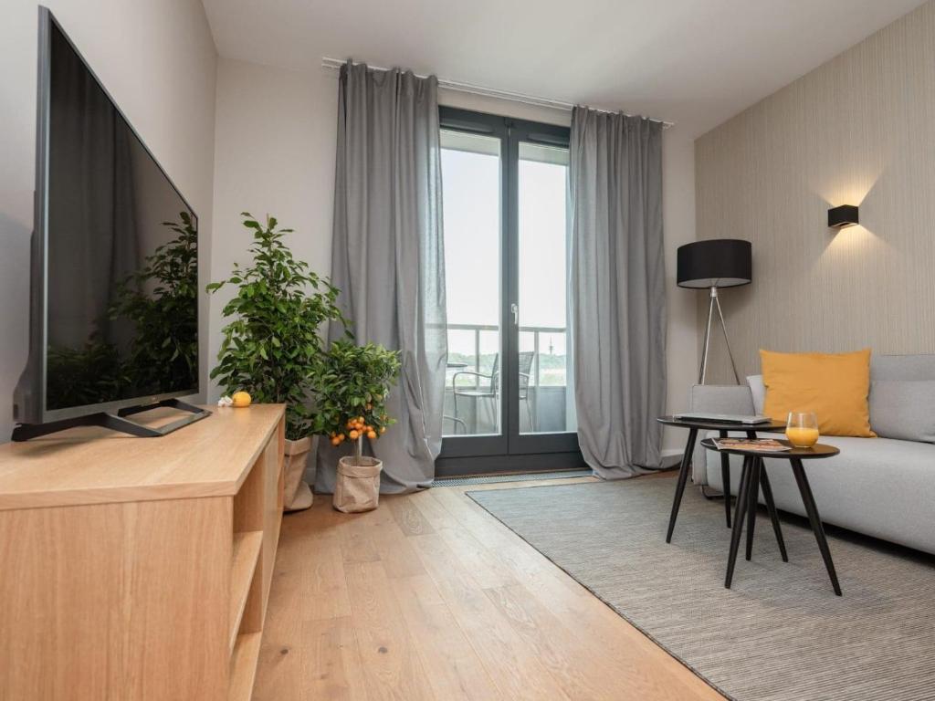 克拉科夫Stylish Apartment Luminis in Krakow's Kazimierz的带沙发和电视的客厅