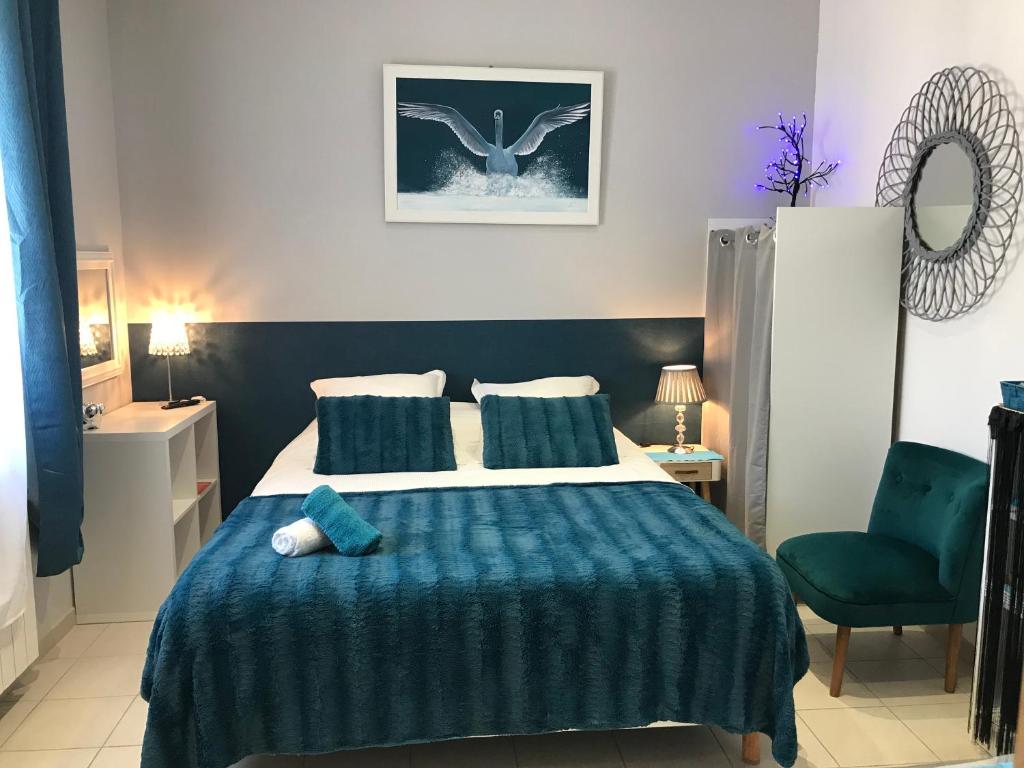 纳博讷La Turenne的一间卧室配有一张带蓝色毯子的大床