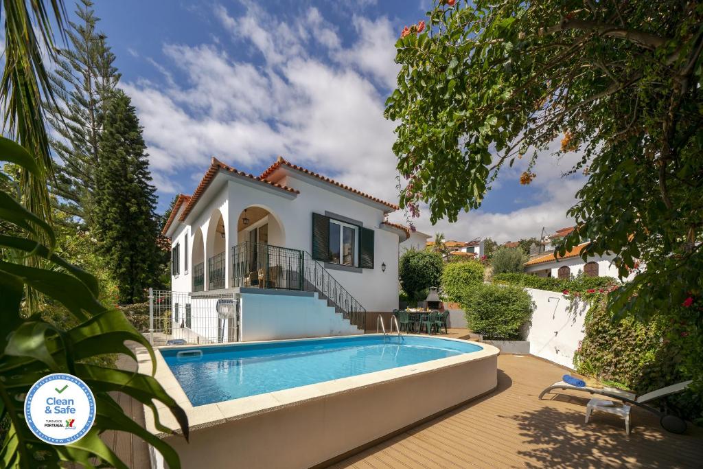 卡尼索Villa Amelia的一座带游泳池和房子的别墅