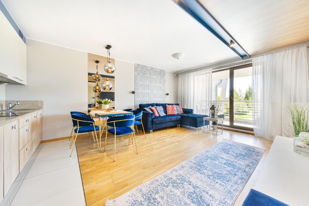 弗瓦迪斯瓦沃沃Klif Residence的厨房以及带蓝色沙发的客厅。