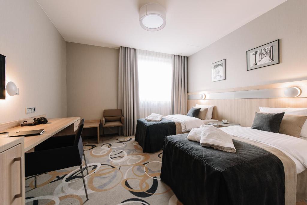 克拉科夫Krowodrza Centrum Konferencyjno - Hotelowe的酒店客房配有两张床和一张书桌