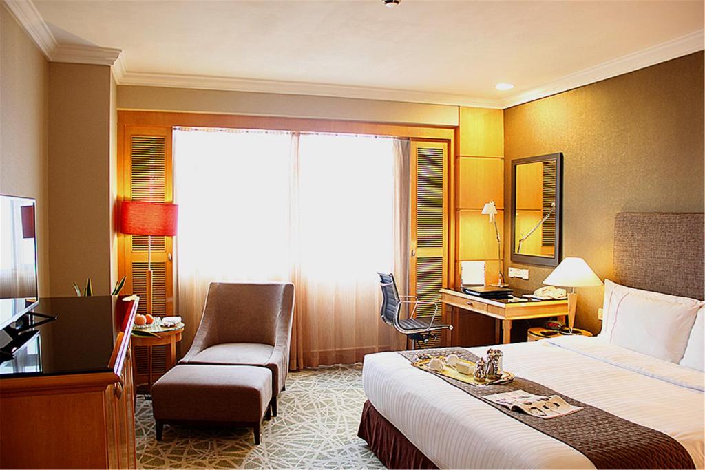 无锡无锡君乐酒店的酒店客房配有一张床、一把椅子和一张书桌
