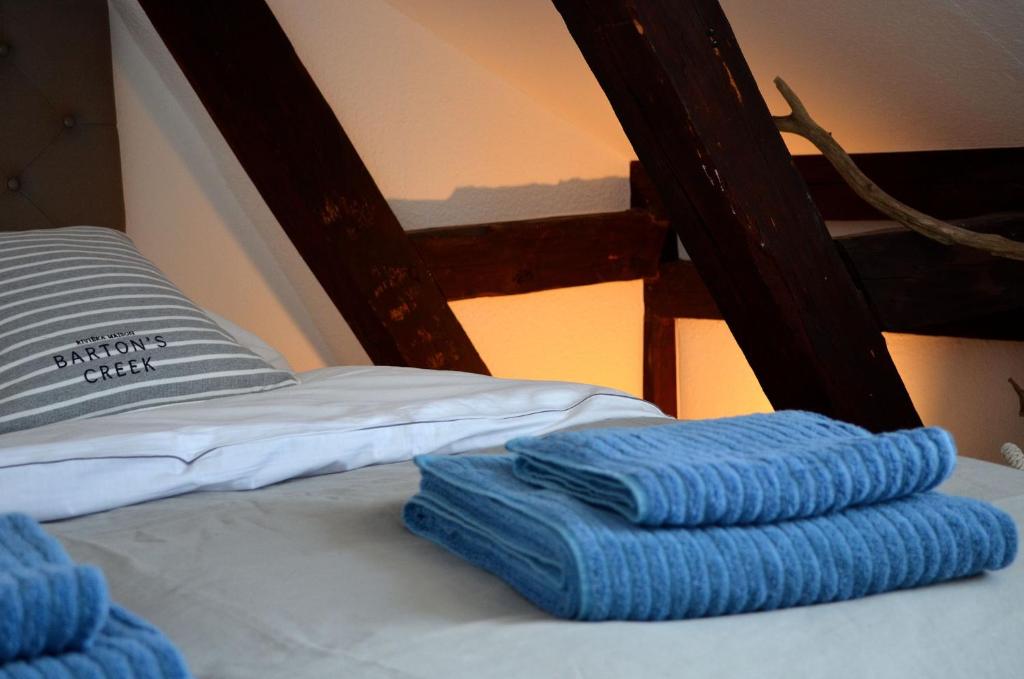 滕宁Solgård - Licht über den Dächern Tönnings的一张带两张蓝色毛巾的床