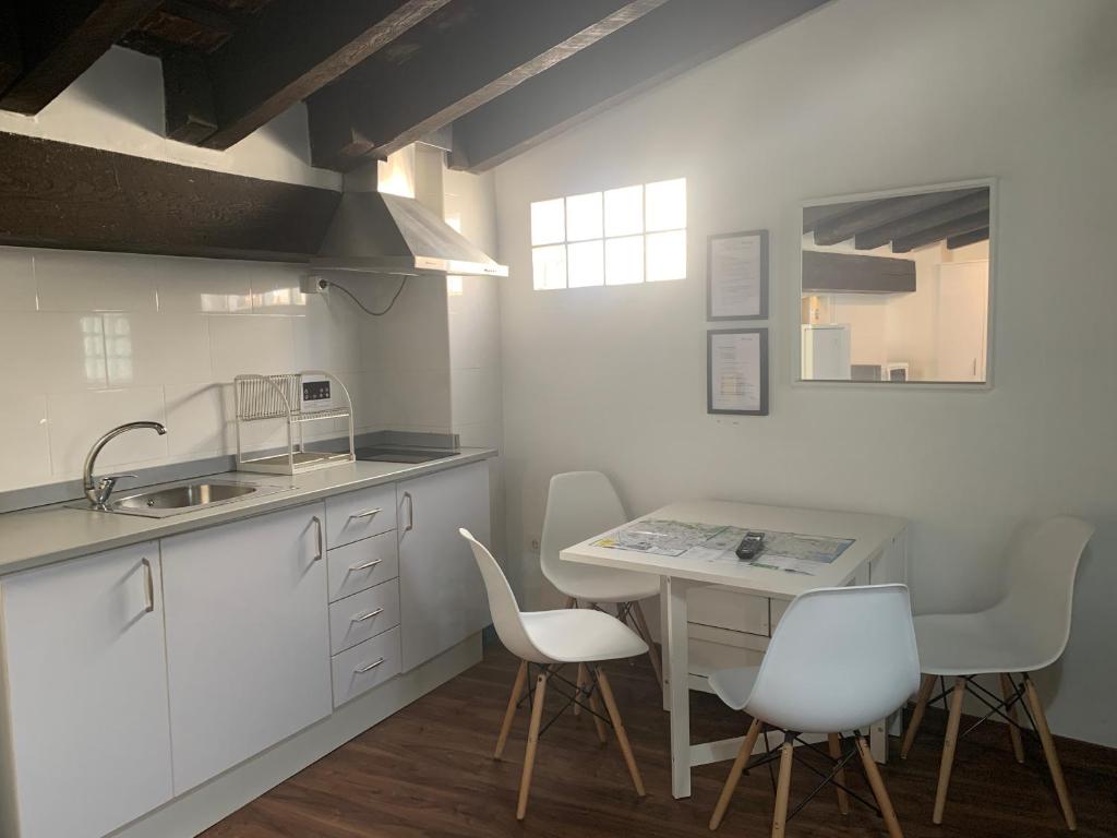 瓦伦西亚市中心区公寓的厨房配有白色橱柜和桌椅