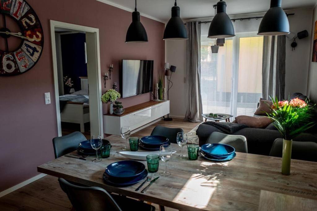 卢布明Ferienwohnung TinyBeach的客厅配有带蓝色菜肴的木桌