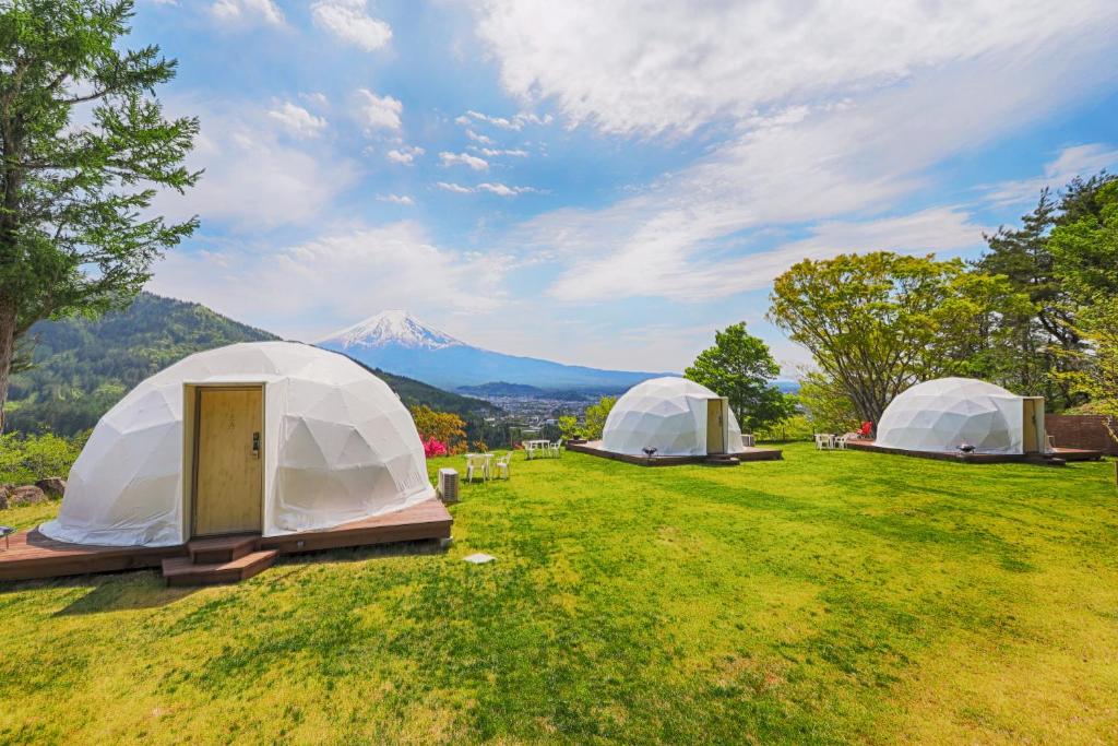 富士吉田市Mt.Shakushi Gateway Camp的两顶帐篷位于山地的田野