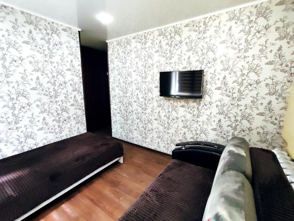 布古拉玛Апартаменты на Сайдашева 3的一间配有沙发的房间和墙上的电视